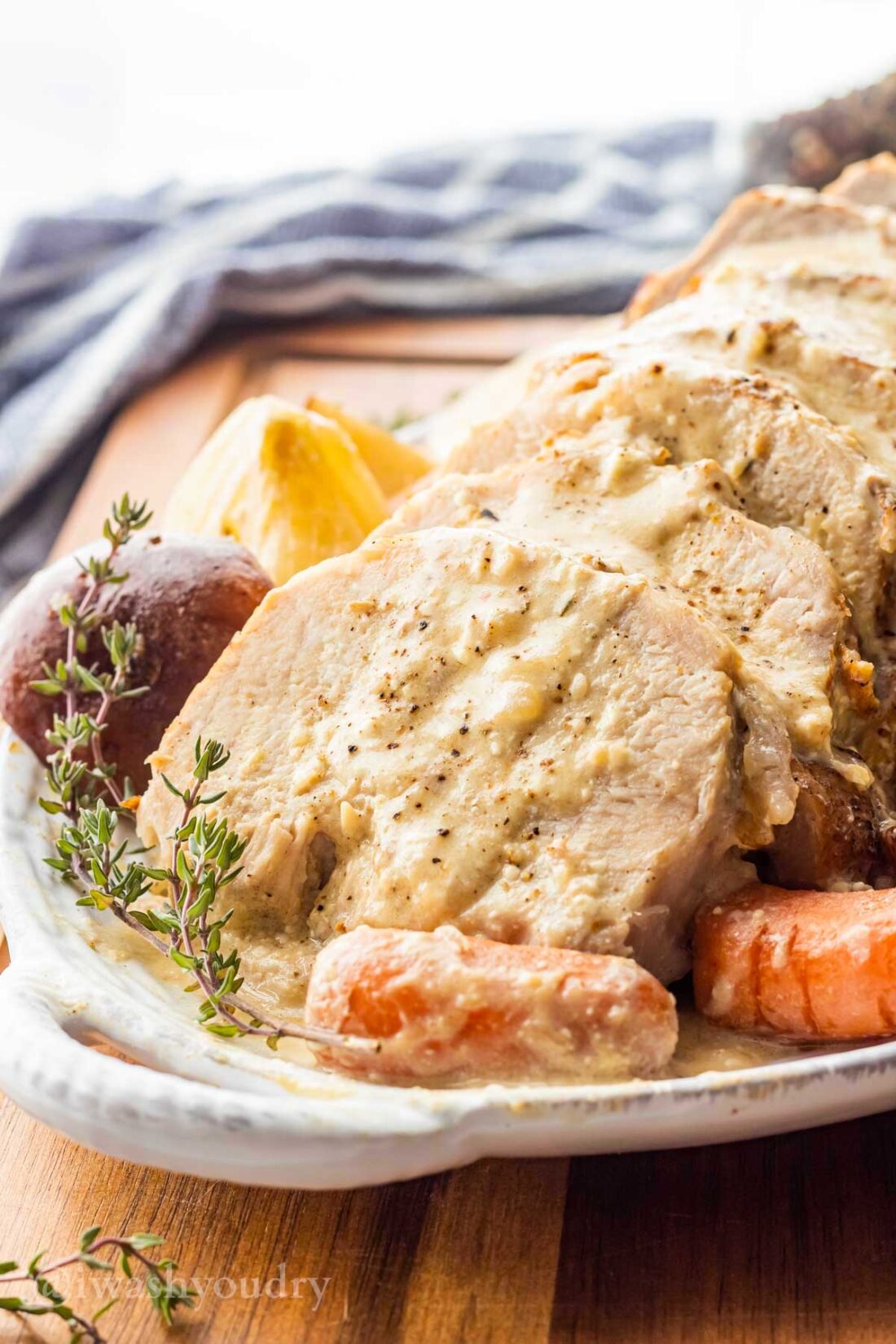 Creamy Garlic Pot Roast with carrots and potatoes on white platter.