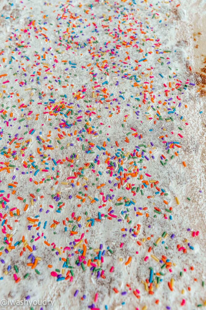 rolled out cinnamon roll dough with sprinkles.