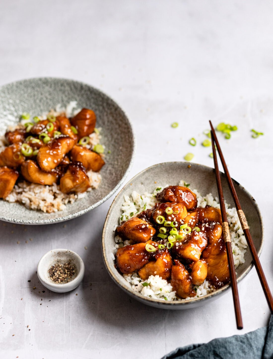 two bowls filled with crispy sesame chicken.