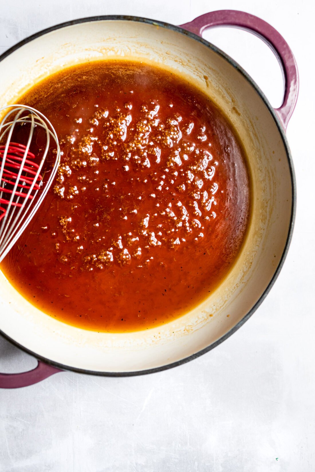 sticky sauce in skillet with whisk.