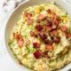 Bowl of cheesy zucchini rice with bacon.