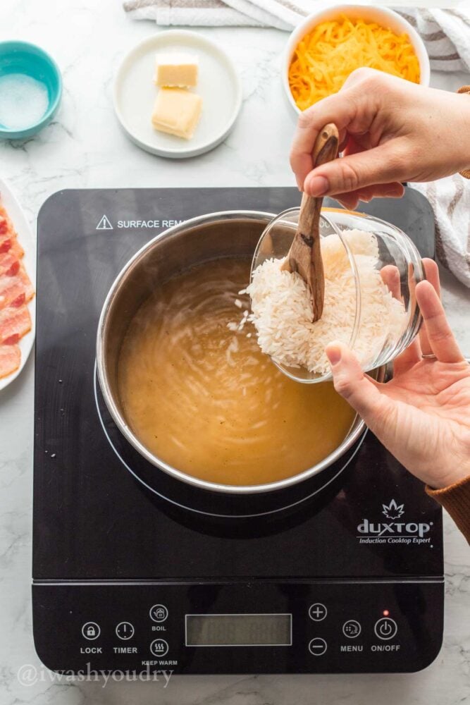 pouring rice into chicken broth.