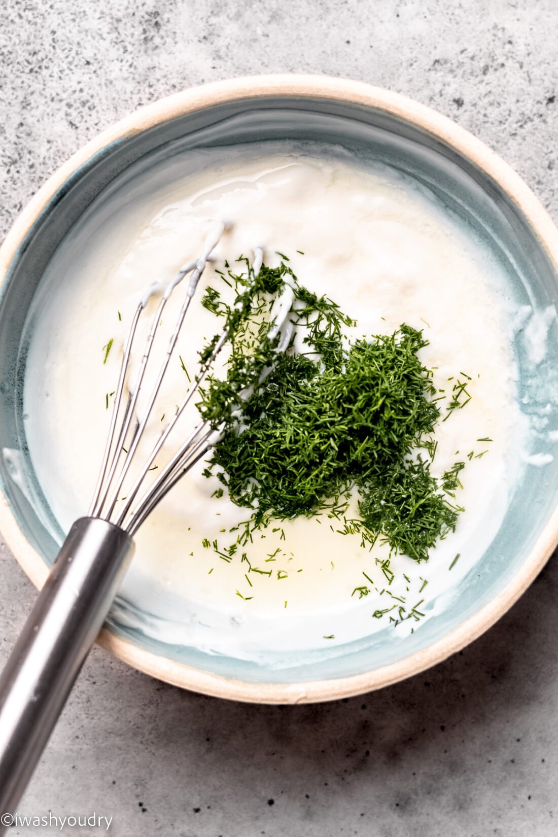 white bowl with dressing and fresh dill.