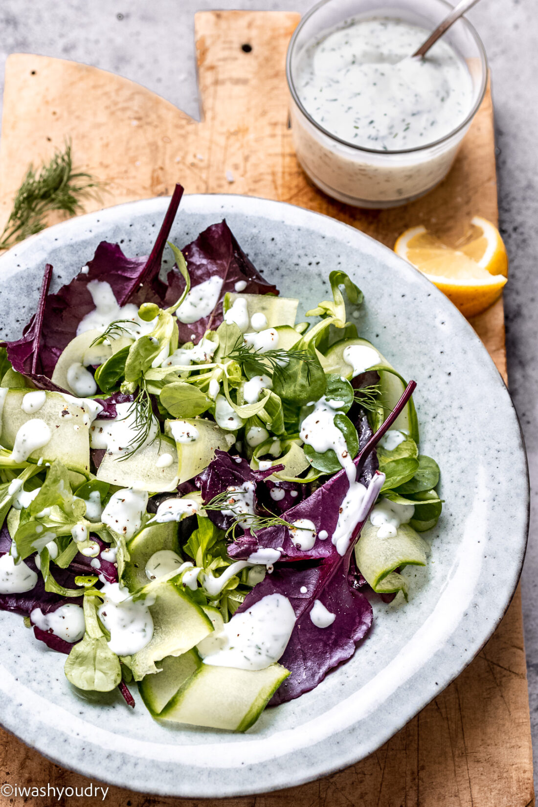 bowl of salad with dressing on top.