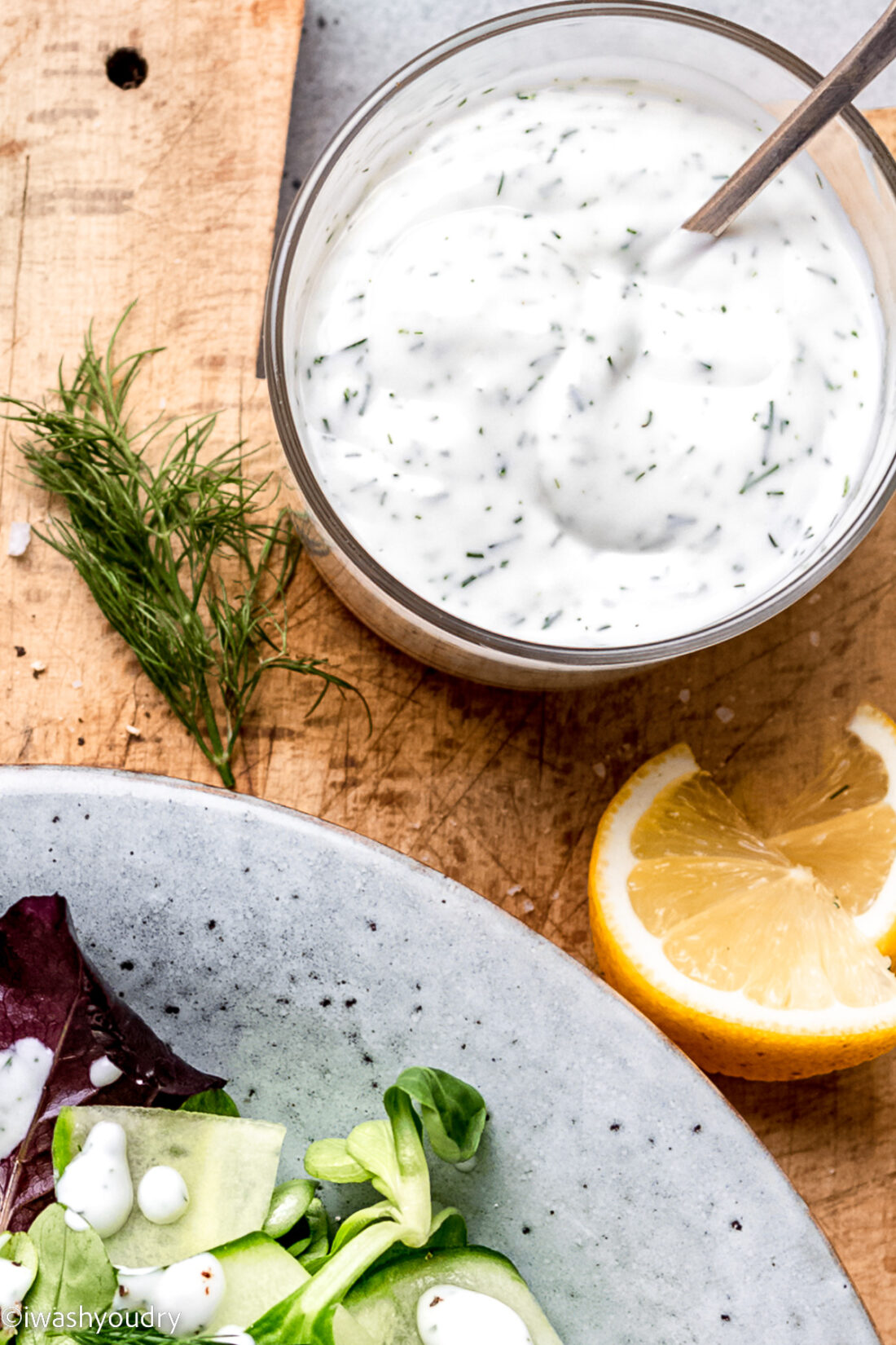 dill dressing in glass bowl with spoon.