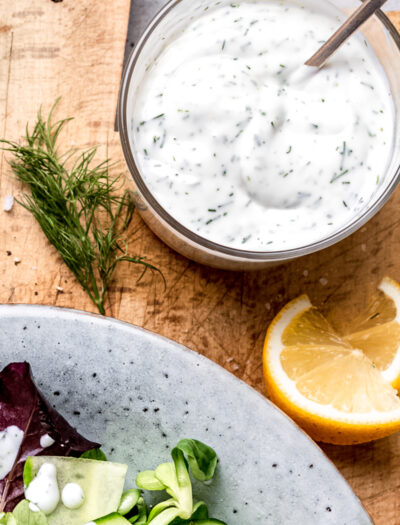 dill dressing in glass bowl with spoon.