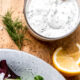 dill dressing in glass bowl with spoon.