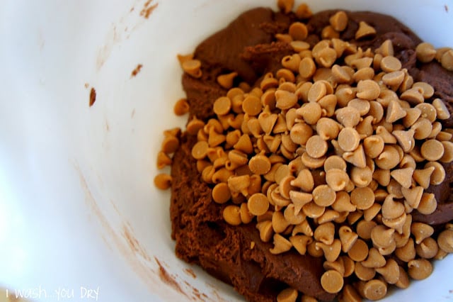Chocolate cookie dough batter in a bowl topped with peanut butter chips