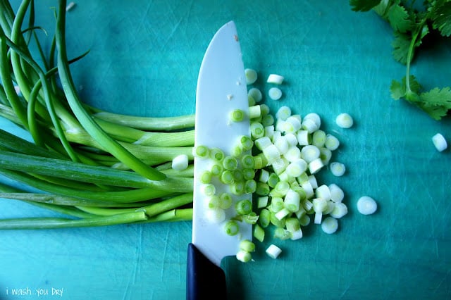 A knife chopping green onions