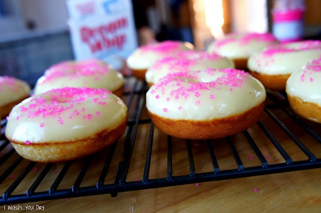 A closeFrosted donuts on a cooling rack with pink sprinkles