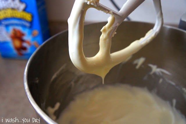 A close up of a mixing paddle over a bowl of batter