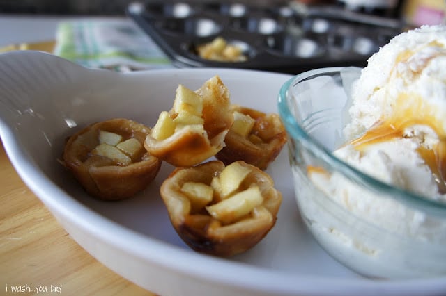 A close up of mini apple pies, one with a bite taken from it. 