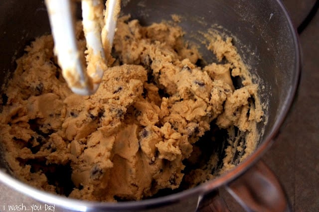 A close up of chocolate chip cookie dough in a mixing bowl