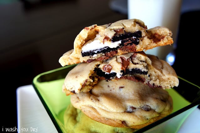 A display of Oreo Stuffed Chocolate Chip Cookies stacked on top of eachother, two split in half to showcase the inside