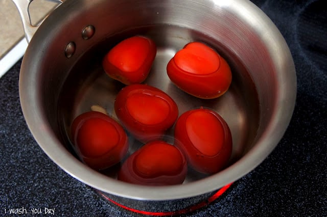 Roma tomatoes and garlic in a pot of water