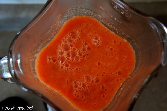 A blender with red sauce in it
