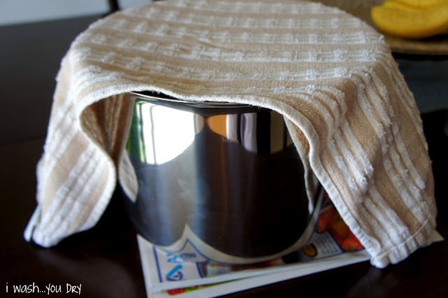 A towel over a pot of rising cinnamon roll dough