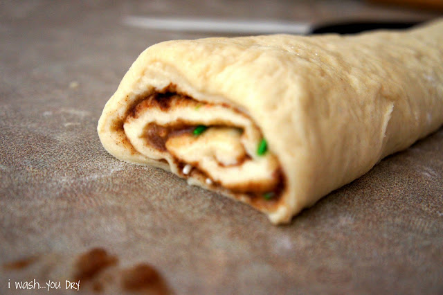 A close up of rolled dough with cinnamon in between the layers, on a counter