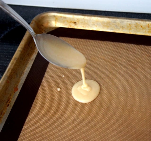 A spoon drizzling the batter on to a baking pan