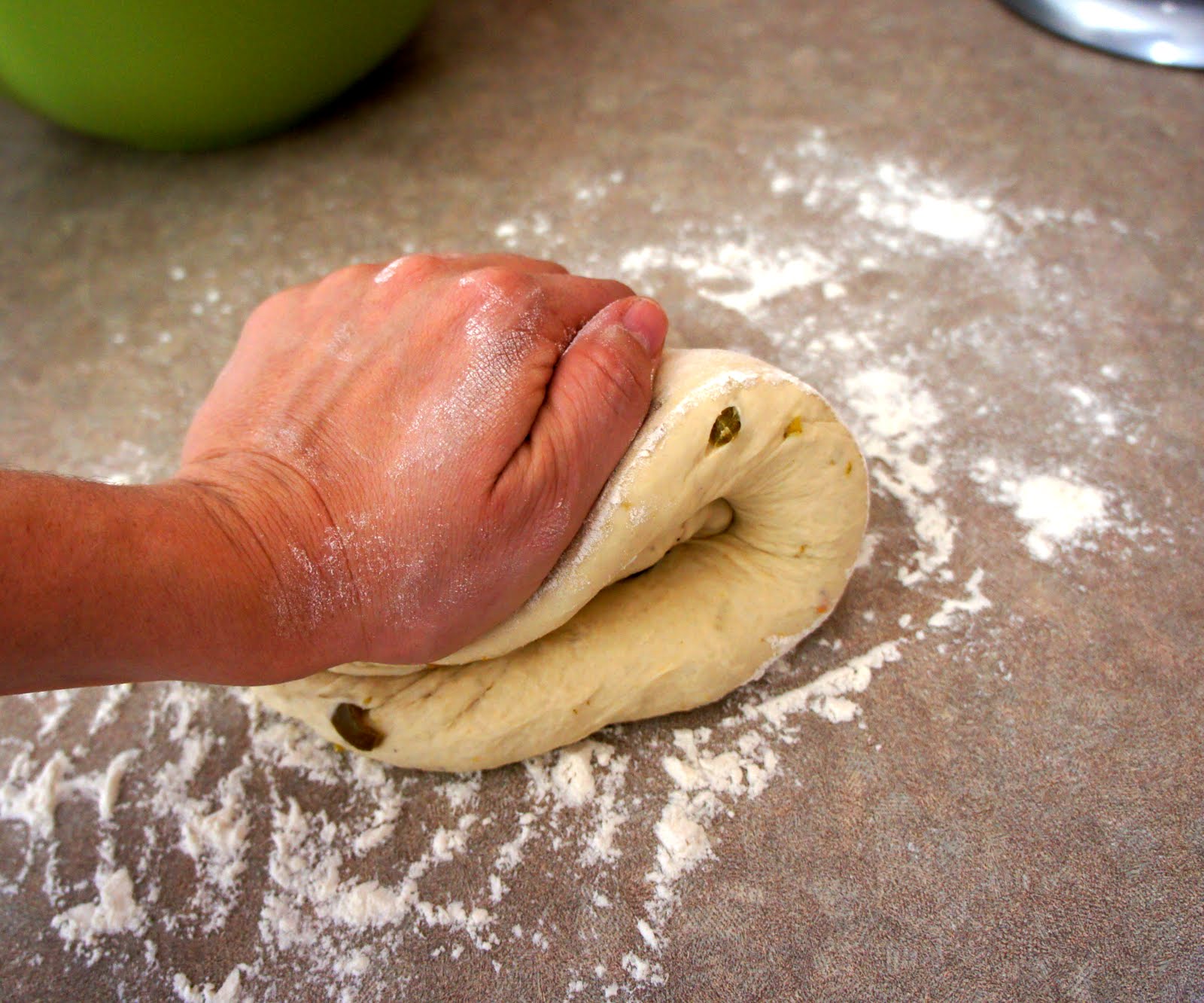 A hand needing the Jalapeño Cheddar Bagel dough