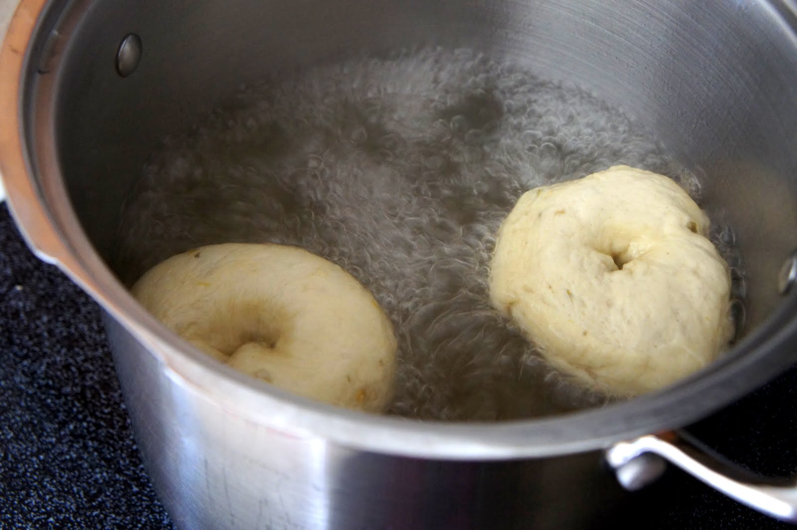 Bagels frying in a pot of oil