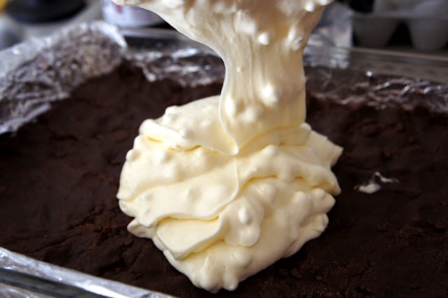 Gooey Hot Chocolate frosting being poured onto a chocolate cake