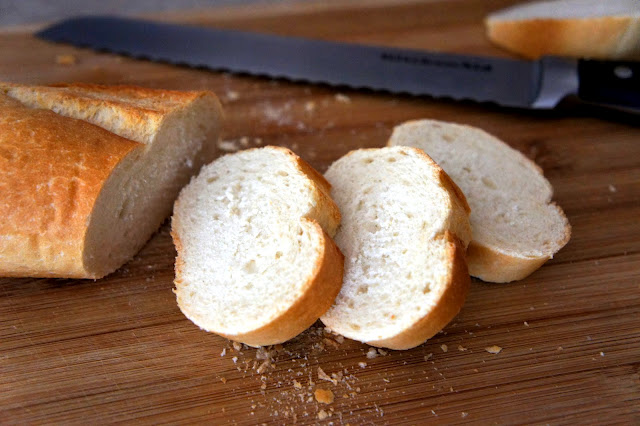 Sliced pieces of French bread on a cutting board 
