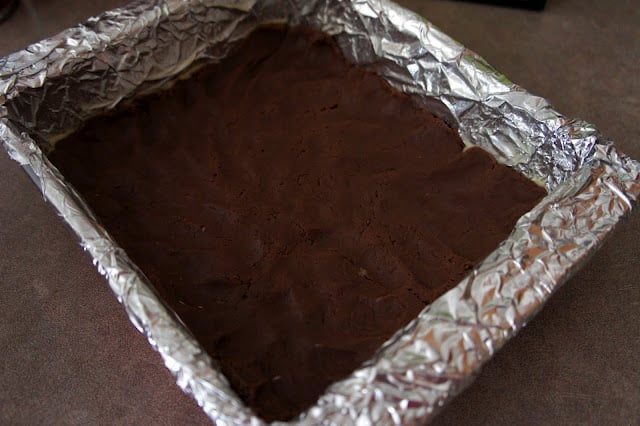 A baking pan with raw brownie dough pressed into it