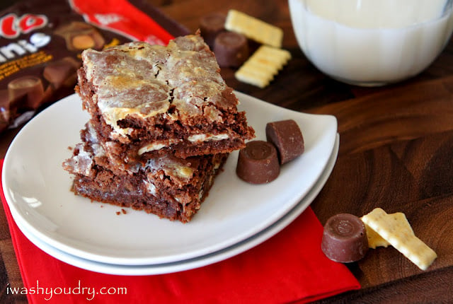 Two squares of Gooey Rolo Cake Bars stacked on top of each other on a plate