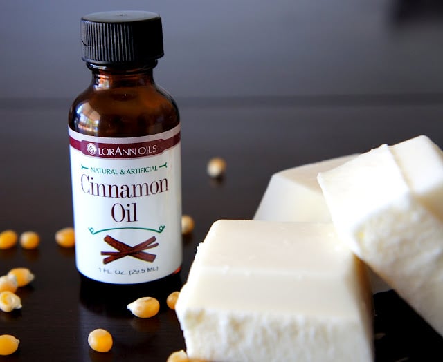 A bottle of cinnamon oil next to some large white chocolate chunks