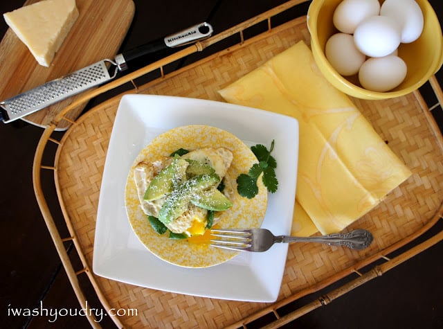 A display of tray with a plate with an Open Faced Egg and Avocado Sandwich on it next to a napkin and a bowl of eggs