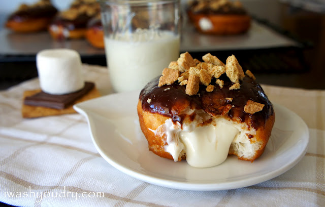 A Marshmallow Cream filled S\'mores Doughnut displayed on a plate next to a glass of milk