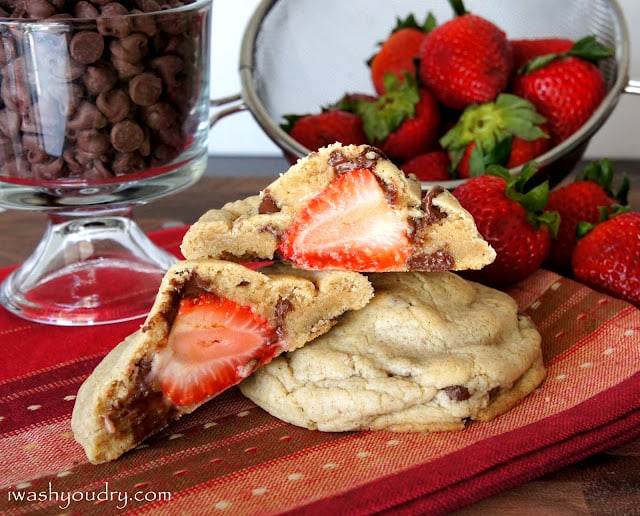 A display of a baked cookie cut open to show the whole strawberry stuffed inside