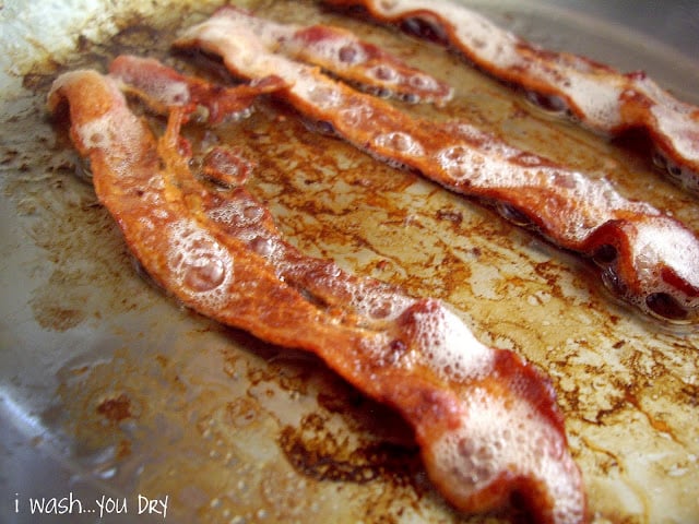 Bacon baking on a baking sheet.