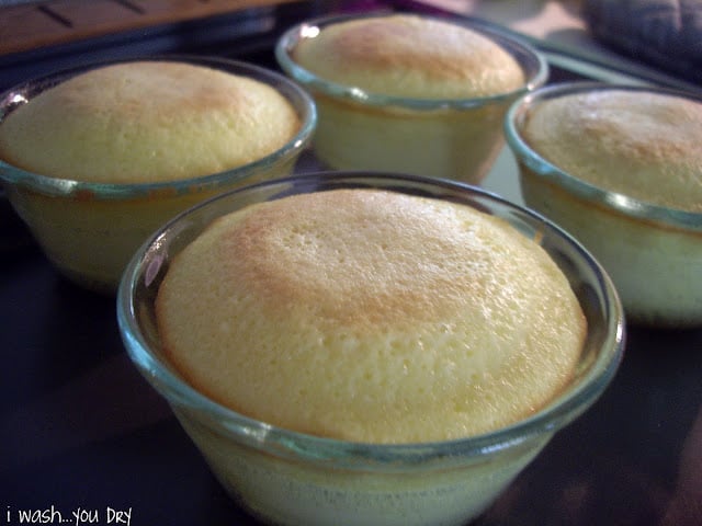 Mini baked cakes in glass dishes on a baking sheet. 