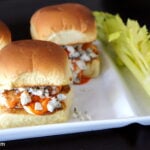 A close up of a plate of sliders filled with buffalo chicken and blue cheese