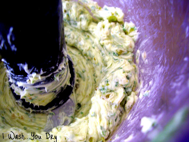 A close up of butter being mixed in a bowl with seasonings.