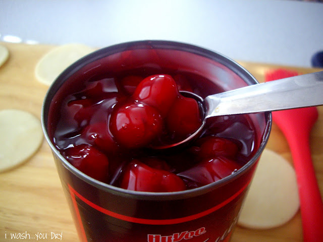 A spoon dipped into a can of cherry pie filling.