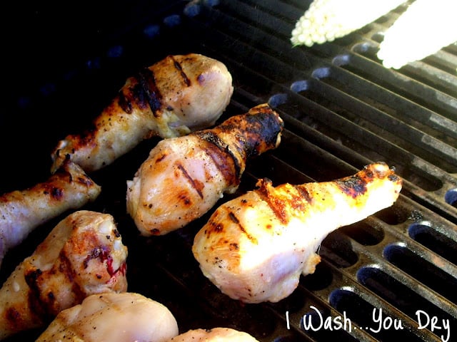 Chicken drumsticks cooking on a grill. 