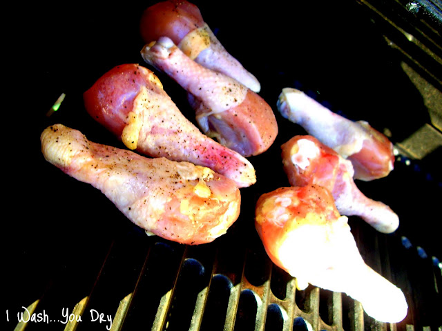Raw chicken drumsticks on a grill. 