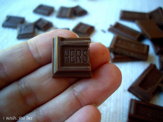 A hand holding half a square of chocolate. 