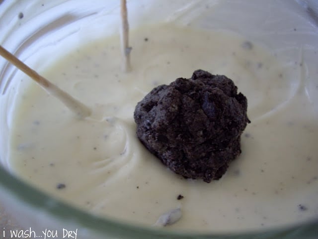 A naked truffle ball in bowl of melted white chocolate.