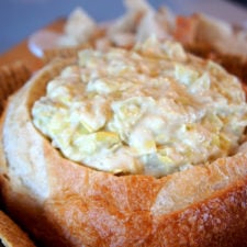 A bread bowl with dip in it.