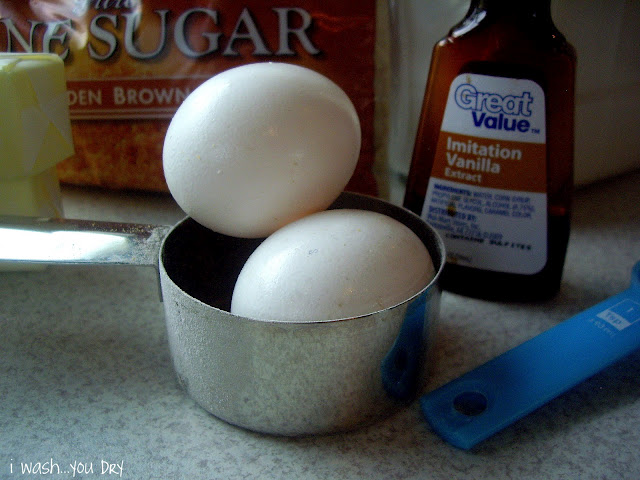 Two uncracked eggs resting in a measuring cup. 