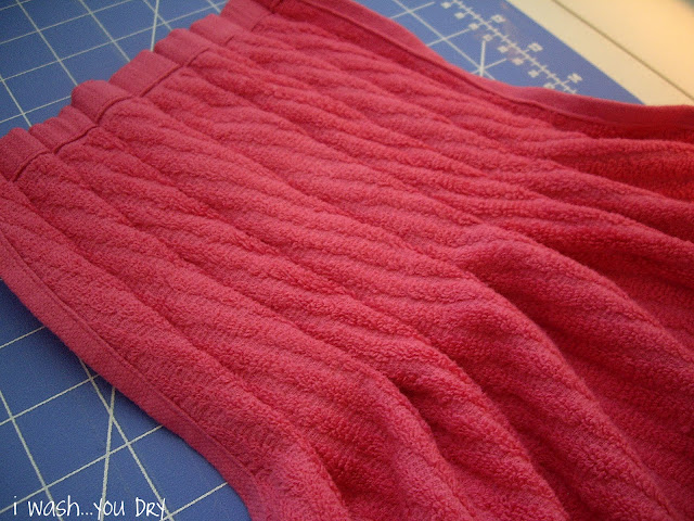The front of a dishtowel with pleats sewed into the top half. 
