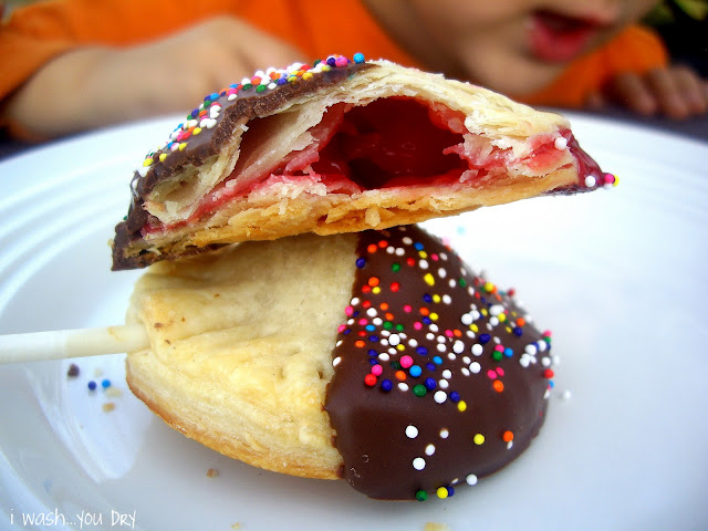 A plate displaying two pie pops with one cut open to showcase the cherry pie filling inside.