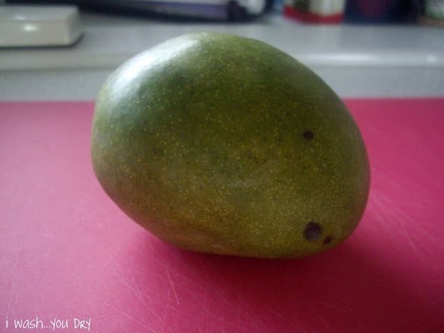 A mango on a cutting board. 