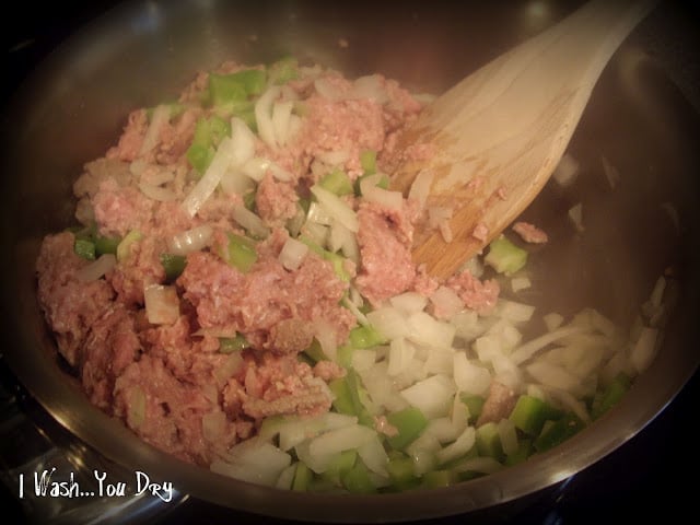 Meat, onions and peppers cooking in a pan. 