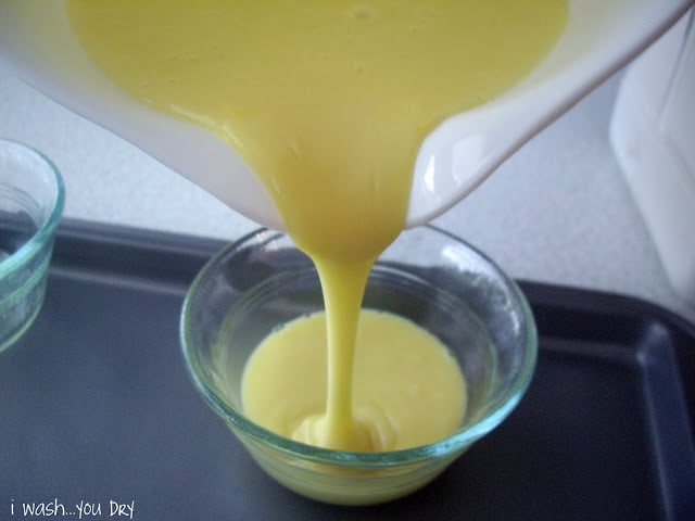 Batter being poured into a small glass desert bowl. 