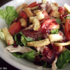 Salad topped with tomatoes and croutons.